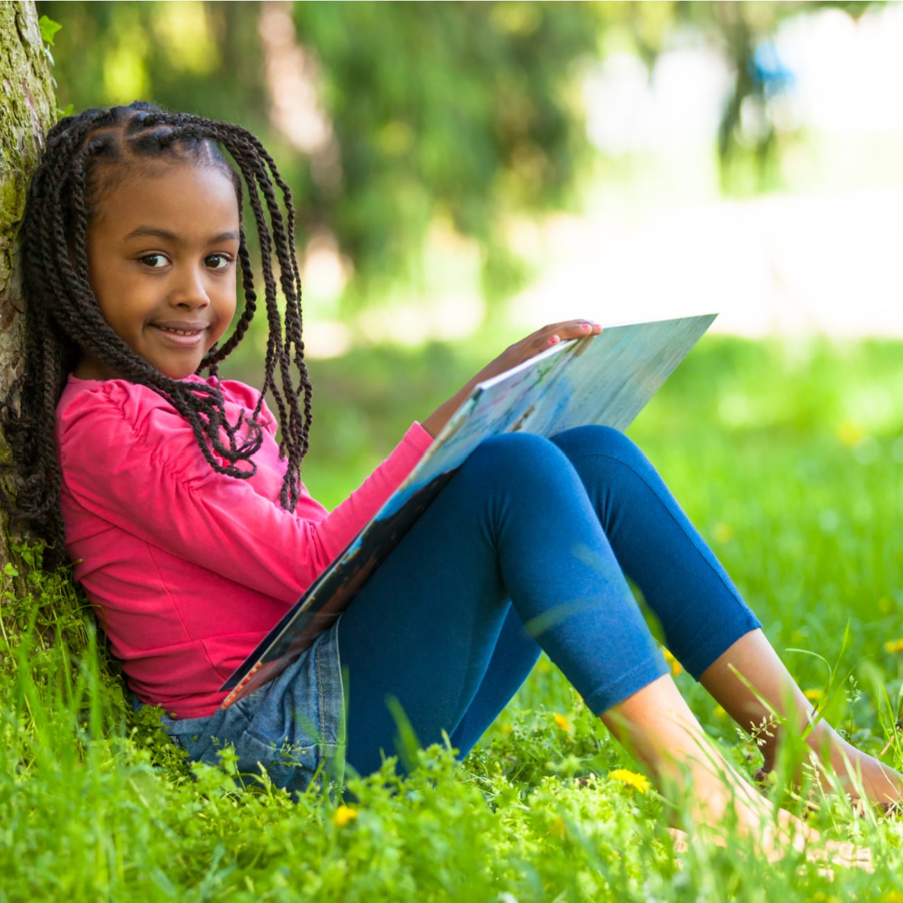 young girl reading outside