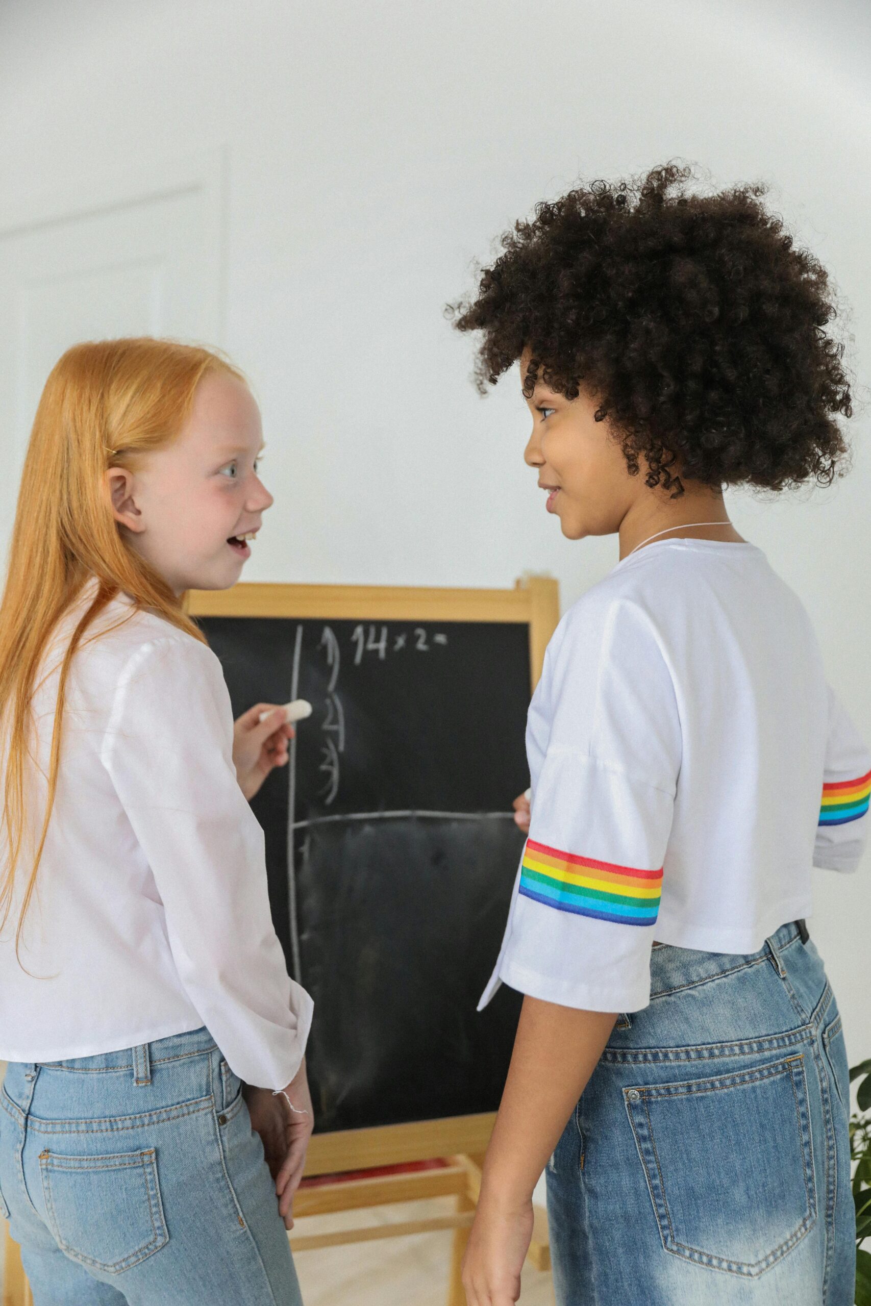 two children learning math at a chalkboard